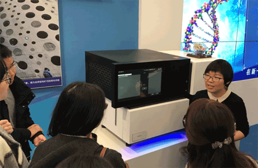 图:华大智造副总裁蒋慧向记者和观众介绍BGISEQ-500